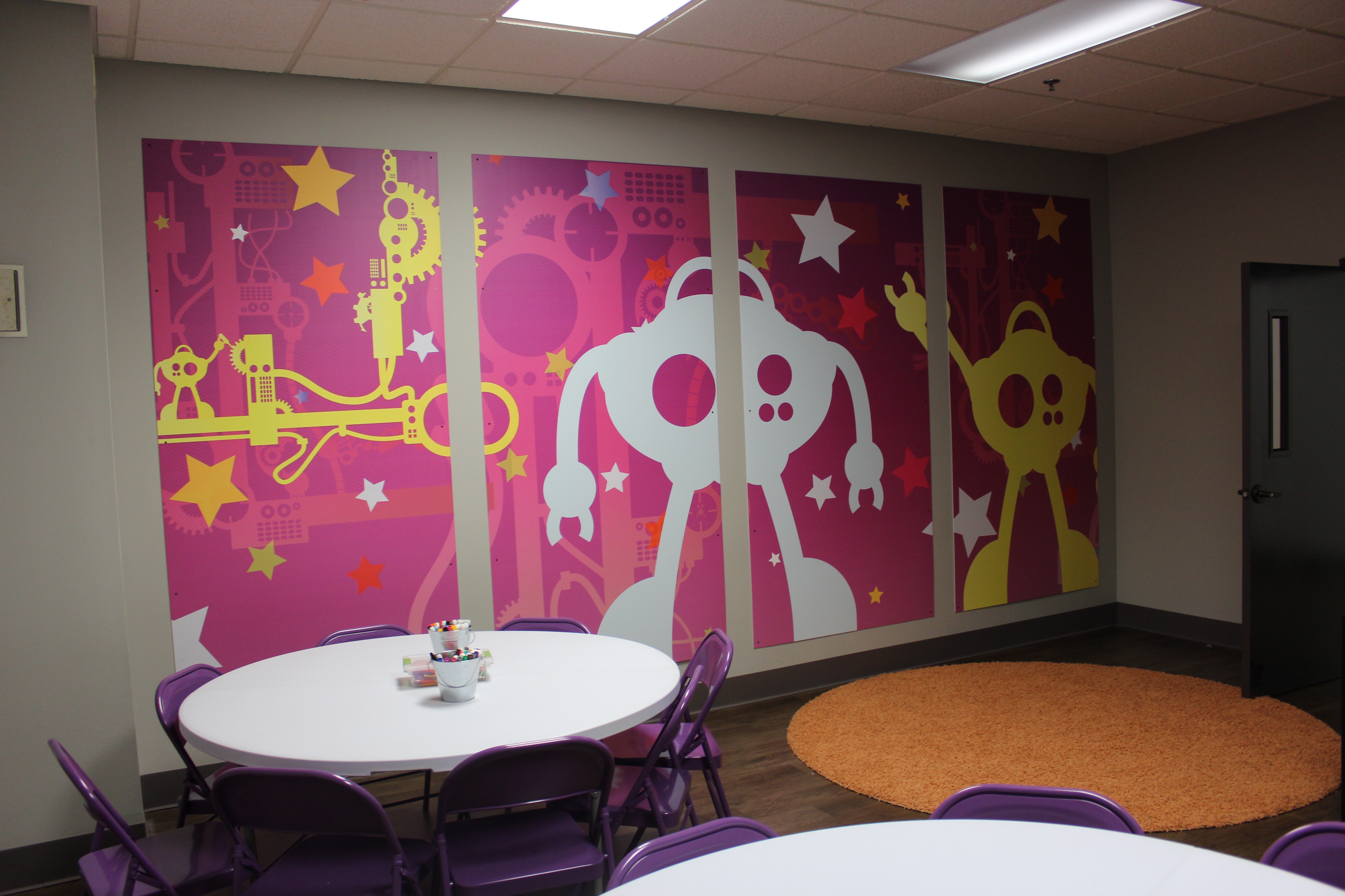 pink and yellow robot signage on wall